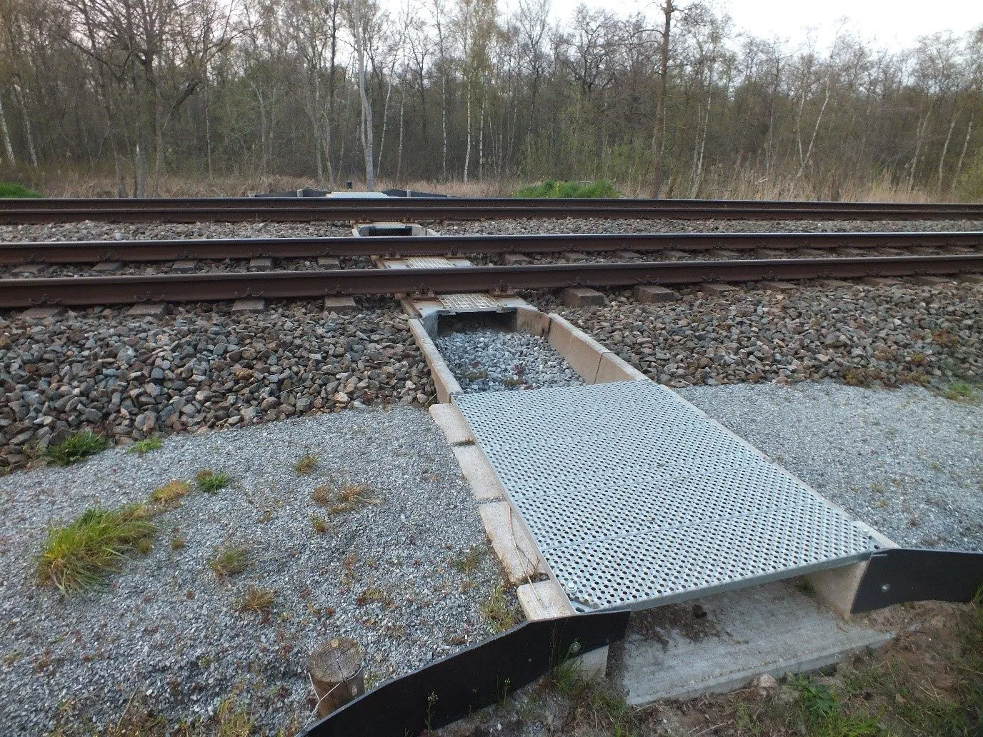 Entrance to the fauna passage with grating deck and retaining walls beside the track