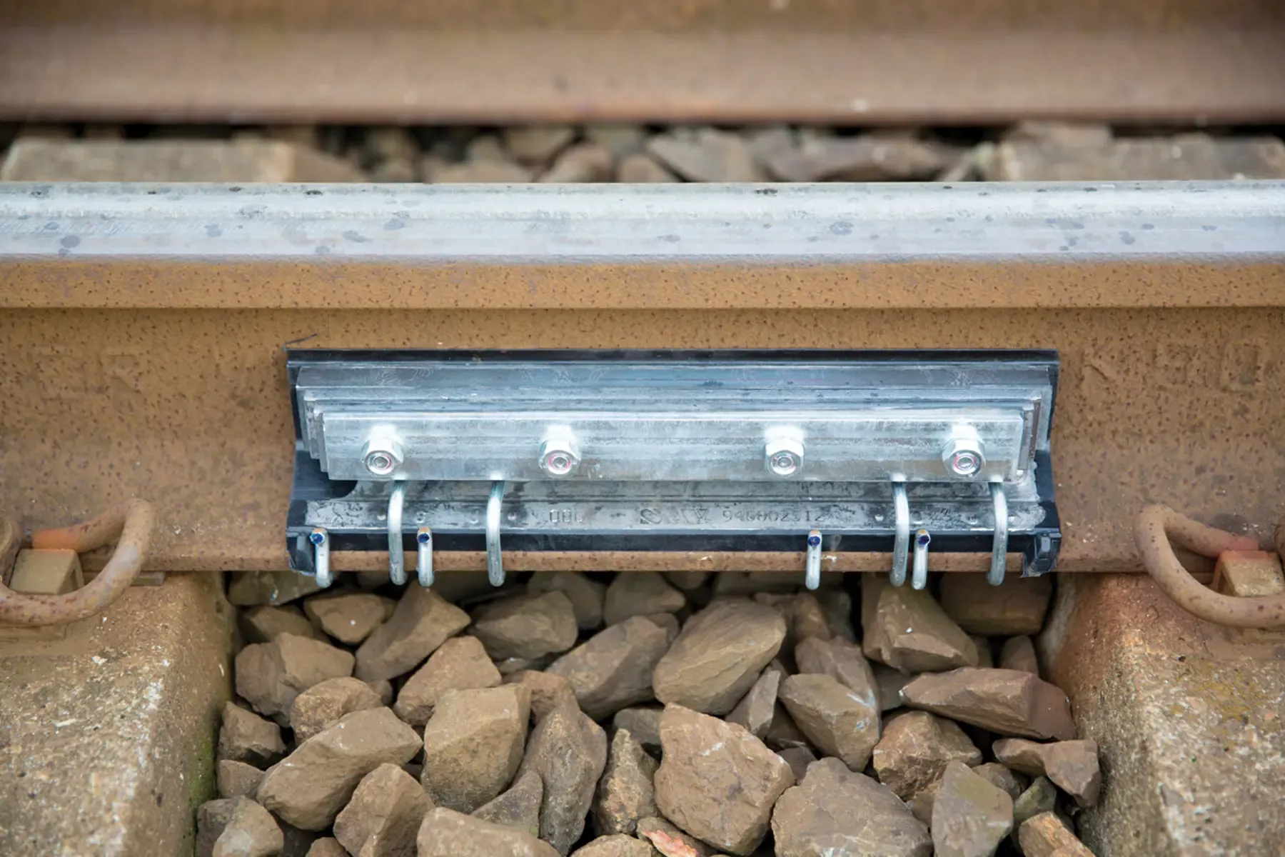 A VICON AMSA rail damper clamped to the rail web, fixed with four bolts and spring clips
